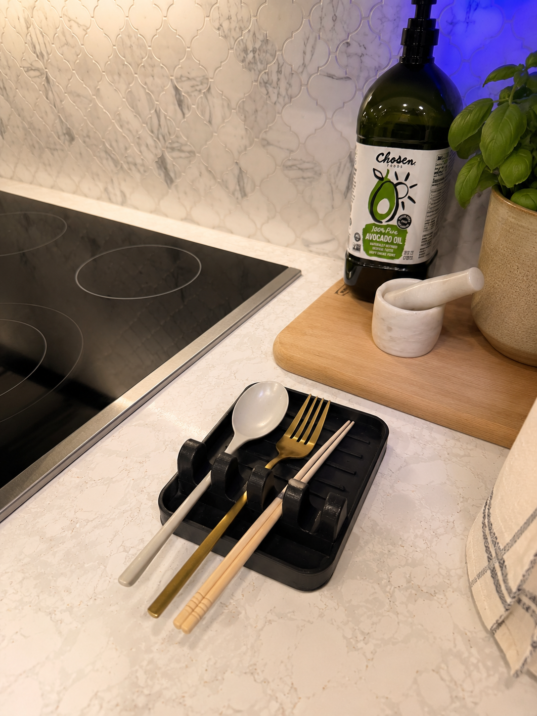 Close-up of the 3D printed PETG spoon rest holding cooking utensils upright beside the stovetop