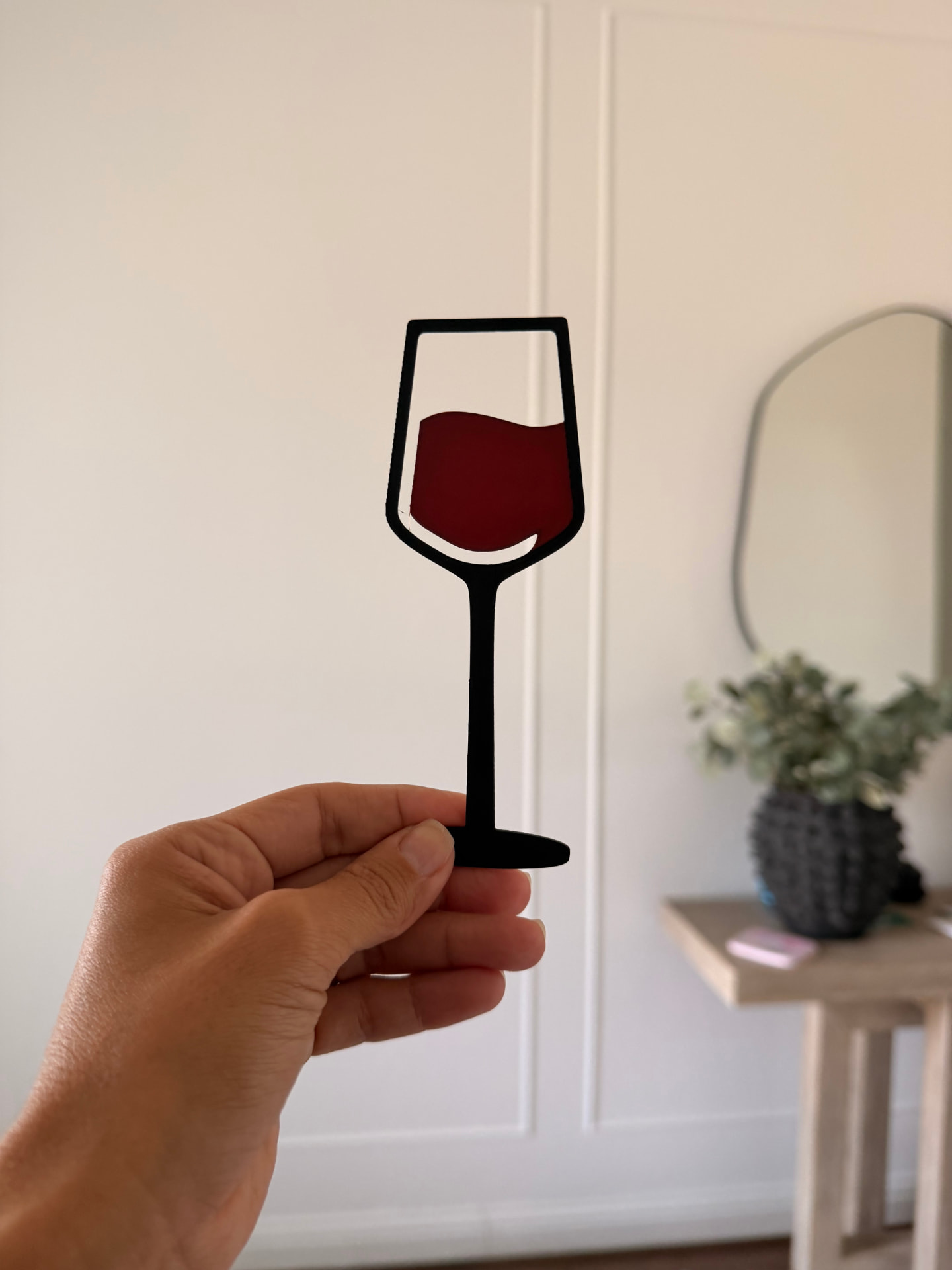 Hand holding the 3D printed wine glass bookmark with red wine detail, a fun gift for book lovers and tidy shelves